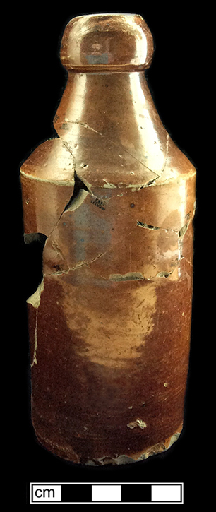 Grey bodied stoneware beer or ginger beer bottle with a dark brown slip glaze of the Albany type. Vessel height: 7.00”, base diameter: 2/50”, MV 6051, from 18PR175.